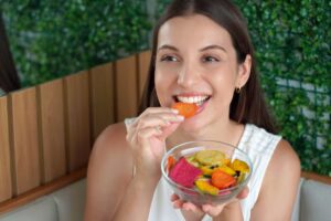 Beautiful young woman eating a mixed of dehydrated vegetables snacks